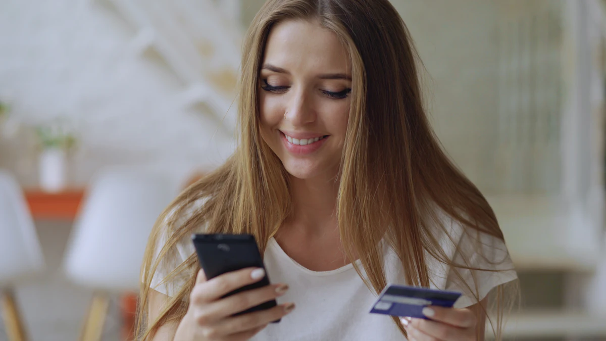Cliente sorrindo com o celular e o cartão na mão